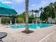 Community pool featuring lounge chairs, palm trees, and shaded pergolas at 1917 Compass Flower Way, Ocoee, FL 34761