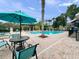 Community pool featuring lounge chairs, palm trees, and shaded pergolas at 1917 Compass Flower Way, Ocoee, FL 34761