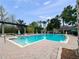Community pool featuring lounge chairs, palm trees, and shaded pergolas at 1917 Compass Flower Way, Ocoee, FL 34761