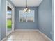 Dining room features tile flooring, a modern chandelier and an exterior door for easy access at 1917 Compass Flower Way, Ocoee, FL 34761