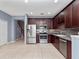Stylish kitchen with stainless appliances, cherry cabinets, tile floors, and easy access to the stairs at 1917 Compass Flower Way, Ocoee, FL 34761