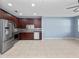 Open floor plan showcasing kitchen with stainless appliances, and cherry cabinets, leading into the living room at 1917 Compass Flower Way, Ocoee, FL 34761