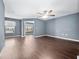 Spacious living room featuring hardwood floors, a ceiling fan, and plenty of natural light at 1917 Compass Flower Way, Ocoee, FL 34761