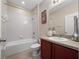 Bright bathroom with a shower and tub combo, and a single sink vanity with storage at 1936 Compass Flower Way, Ocoee, FL 34761