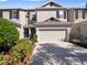 Attractive exterior showcasing a two-story townhouse with an attached garage and landscaped surroundings at 1936 Compass Flower Way, Ocoee, FL 34761