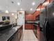 Well-appointed kitchen with dark wood cabinets, black appliances, and a large center island for meal prep and entertaining at 1936 Compass Flower Way, Ocoee, FL 34761