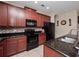 Kitchen featuring stainless steel appliances, granite countertops, tile backsplash, and dark wood cabinetry at 1936 Compass Flower Way, Ocoee, FL 34761