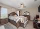 Large main bedroom with an elegant bed frame, ceiling fan, and ample natural light at 1936 Compass Flower Way, Ocoee, FL 34761