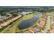 An aerial view of a golf course and a lake surrounding homes in a residential neighborhood at 2376 Palm Tree Dr, Kissimmee, FL 34759