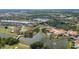 An aerial view showcases a community featuring a clubhouse, pool, golf course, and lake at 2376 Palm Tree Dr, Kissimmee, FL 34759