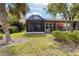 Backyard featuring a screened in lanai and green grass at 2376 Palm Tree Dr, Kissimmee, FL 34759