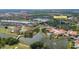An aerial view showcases a community featuring a clubhouse, pool, golf course, and lake at 2376 Palm Tree Dr, Kissimmee, FL 34759