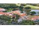Aerial view featuring a clubhouse, pool, and golf course, surrounded by lush greenery and manicured grounds at 2376 Palm Tree Dr, Kissimmee, FL 34759