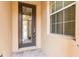 A welcoming front door features a glass panel, with a window on the side, on a charming textured exterior and stone tile entry at 2376 Palm Tree Dr, Kissimmee, FL 34759