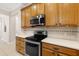 A well-lit kitchen features stainless steel appliances, wooden cabinets, tiled floors and backsplash, and white countertops at 2376 Palm Tree Dr, Kissimmee, FL 34759