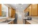 A galley kitchen featuring wood cabinets, stainless steel appliances, tile backsplash, and lots of natural light from a large window at 2376 Palm Tree Dr, Kissimmee, FL 34759