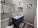 Well-lit bathroom featuring a vanity with blue cabinet, modern fixtures, and decorative accents at 2531 Old Kent Cir, Kissimmee, FL 34758