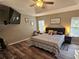 Bedroom with a modern ceiling fan, dark wood floors and a decorative sign above the bed at 2531 Old Kent Cir, Kissimmee, FL 34758