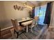 Elegant dining room with a modern light fixture, seating for six, and sliding glass doors at 2531 Old Kent Cir, Kissimmee, FL 34758