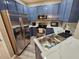 Bright kitchen features stainless steel appliances, sink and blue cabinets at 2531 Old Kent Cir, Kissimmee, FL 34758