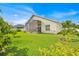 A bright sunny view of the green backyard with a screened-in patio and a white home exterior at 2642 Gild Dust Cir., Kissimmee, FL 34744