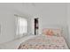 Bright bedroom with white walls, a large window and a bed with coral seashell patterned bedding at 2642 Gild Dust Cir., Kissimmee, FL 34744