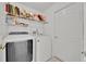 The laundry room is equipped with a washer, dryer, and wire shelving for storage at 2642 Gild Dust Cir., Kissimmee, FL 34744