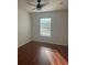 Bright bedroom featuring a ceiling fan, window, and wood-look flooring at 2650 Patrician Cir, Kissimmee, FL 34746