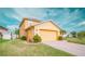 Two-story home featuring a two-car garage, a lush lawn, and mature trees at 2650 Patrician Cir, Kissimmee, FL 34746