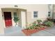 Charming townhouse entrance with red door and freshly landscaped garden at 2729 Club Cortile Cir, Kissimmee, FL 34746