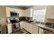 Well-lit kitchen features stainless steel appliances, granite counters, and window at 2729 Club Cortile Cir, Kissimmee, FL 34746