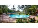 Community pool surrounded by mature trees and a brick pool deck is perfect for relaxation at 2864 N Powers Dr # 150, Orlando, FL 32818