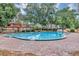 Community pool surrounded by mature trees and a brick deck is perfect for relaxation at 2864 N Powers Dr # 150, Orlando, FL 32818