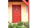 Inviting condo entrance featuring a vibrant red door, unit number 150, and well-maintained exterior at 2864 N Powers Dr # 150, Orlando, FL 32818