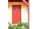 Inviting condo entrance featuring a vibrant red door, unit number 150, and well-maintained exterior at 2864 N Powers Dr # 150, Orlando, FL 32818