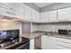 Functional kitchen features white cabinets, granite countertops, and stainless steel appliances at 2864 N Powers Dr # 150, Orlando, FL 32818