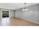 Spacious living room illuminated by a modern chandelier and features a sliding door to outside at 2864 N Powers Dr # 150, Orlando, FL 32818