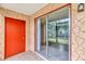 Screened patio with a red door and beige stucco wall next to a sliding glass door at 2864 N Powers Dr # 150, Orlando, FL 32818