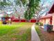Outdoor picnic area with multiple picnic tables and barbecue is surrounded by mature trees at 2864 N Powers Dr # 150, Orlando, FL 32818