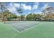 Well-maintained community tennis court surrounded by mature landscaping on a sunny day at 2864 N Powers Dr # 150, Orlando, FL 32818