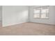 Spacious bedroom with neutral carpet, featuring a large window providing plenty of natural light at 2922 Crest Dr, Kissimmee, FL 34744