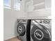 Well-equipped laundry room featuring modern washer and dryer with overhead storage space at 2922 Crest Dr, Kissimmee, FL 34744