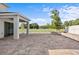 Brick patio with covered porch overlooks the fenced yard with mature trees at 2922 Crest Dr, Kissimmee, FL 34744