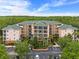 Attractive condo building features multiple floors and a large parking lot nestled near a lush forest at 3060 Pirates Retreat Ct # 309, Kissimmee, FL 34747