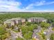 Aerial view of a condo complex with parking surrounded by lush Florida greenery at 3060 Pirates Retreat Ct # 309, Kissimmee, FL 34747
