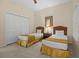 This bedroom features two twin beds, carpet and a double closet at 3060 Pirates Retreat Ct # 309, Kissimmee, FL 34747