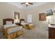 This bedroom has two twin beds and a mounted television with a ceiling fan at 3060 Pirates Retreat Ct # 309, Kissimmee, FL 34747