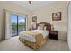 Bedroom with a sliding glass door to a balcony, queen bed, and two side tables at 3060 Pirates Retreat Ct # 309, Kissimmee, FL 34747