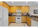 Efficient kitchen features essential appliances, wood cabinetry, and easy access to adjacent living areas at 3060 Pirates Retreat Ct # 309, Kissimmee, FL 34747