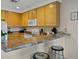Practical kitchen with wood cabinets and appliances, complemented by a breakfast bar with stool seating at 3060 Pirates Retreat Ct # 309, Kissimmee, FL 34747